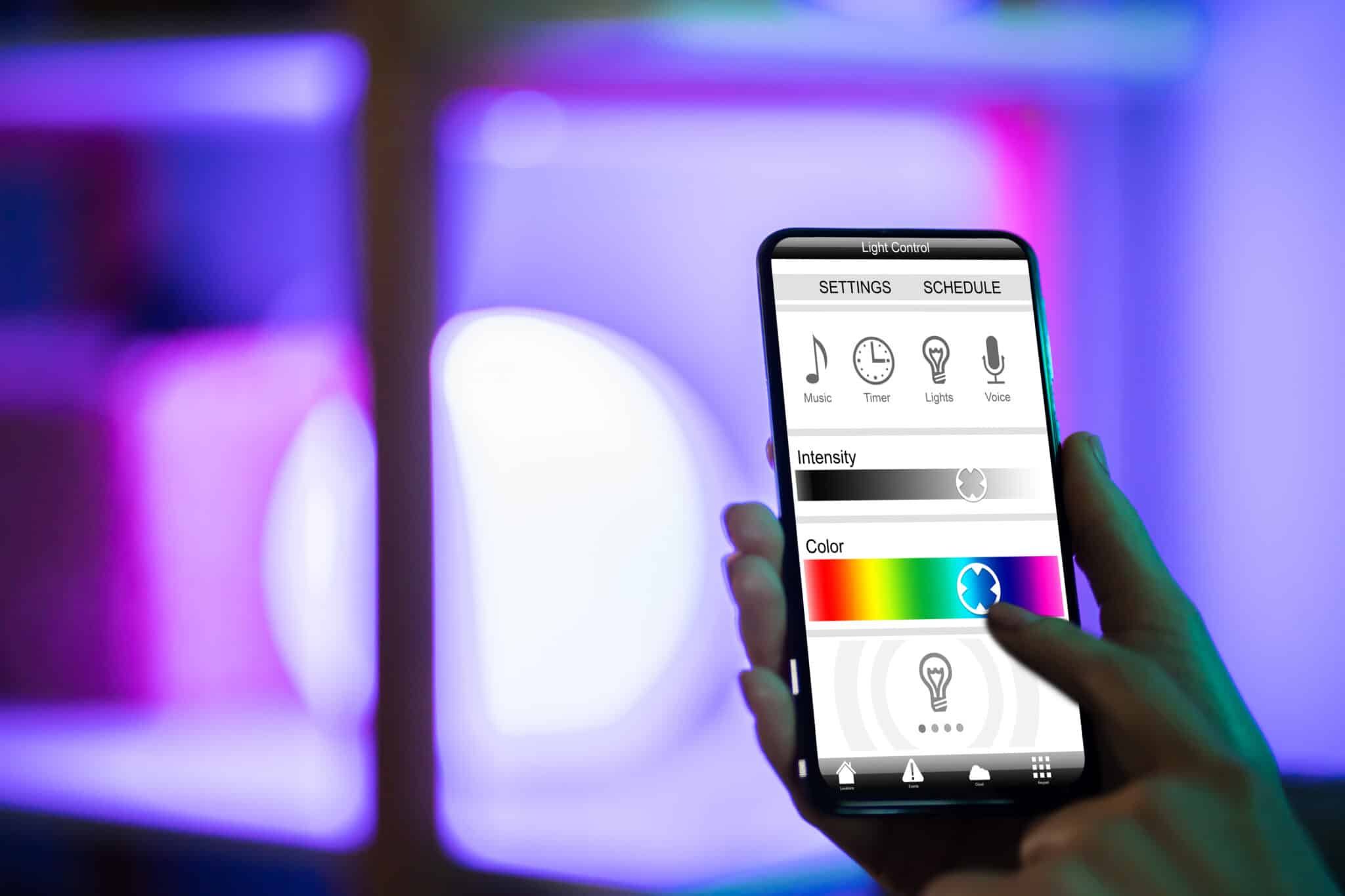A Person Controlling Programmable Lighting with a Phone App.