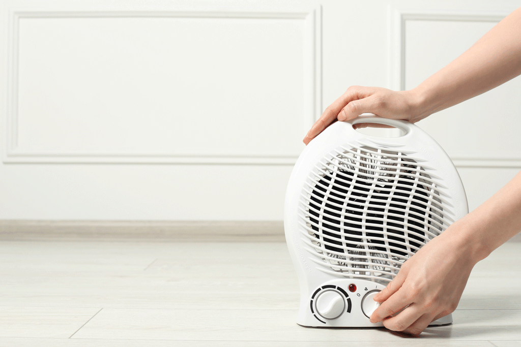 lady turning on space heater space heater safety tips canton tx mabank tx